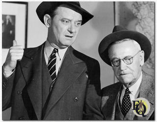 Sergeant Velie (James Burke) explains to Inspector Queen (Grapewin) in "A Close Call for Ellery Queen" (1942).