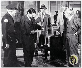Afgelijnde zone waar het lichaam viel en grimmige verzamelplaats voor de hoofdrolspelers in "Ellery Queen" met de kleuruitzending van "The Pharoah's Curse" Van links zie je Wallace Rooney als museumbewaker, Ross Martin als museumdirecteur, Tom Reese al sergeant Velie, Jim Hutton als Ellery Queen en David Wayne als Inspecteur Queen.